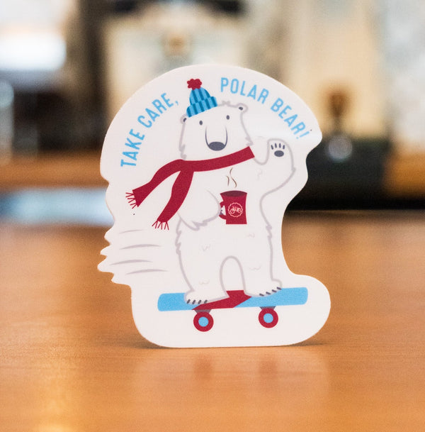 sticker featuring a polar bear skateboarding and drinking from a red mug.  Words say Take Care Polar Bear 