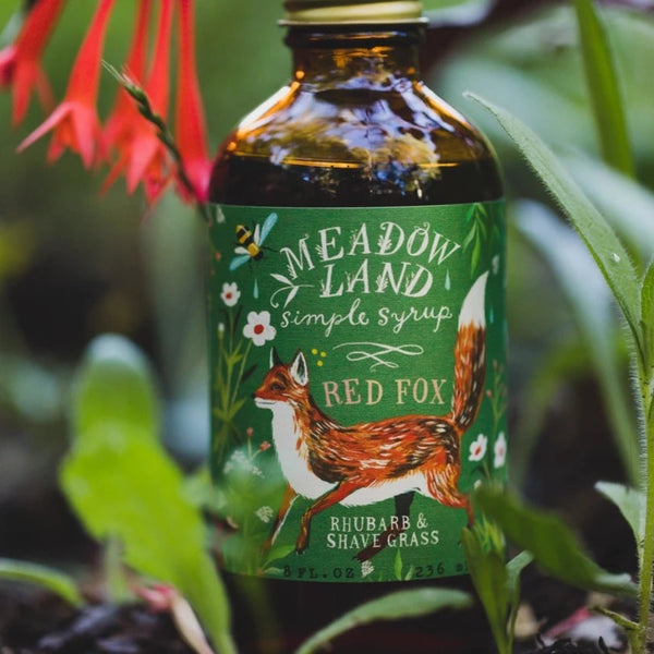Meadowland brand syrup called Red Fox.  Rhubarb and Shave Grass flavored featuring a red fox on a green plant background