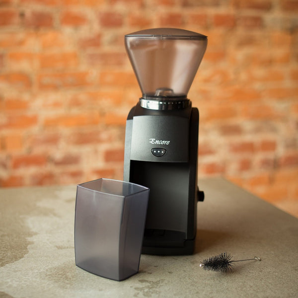 Black coffee grinder with the brand baratza encore on it.  