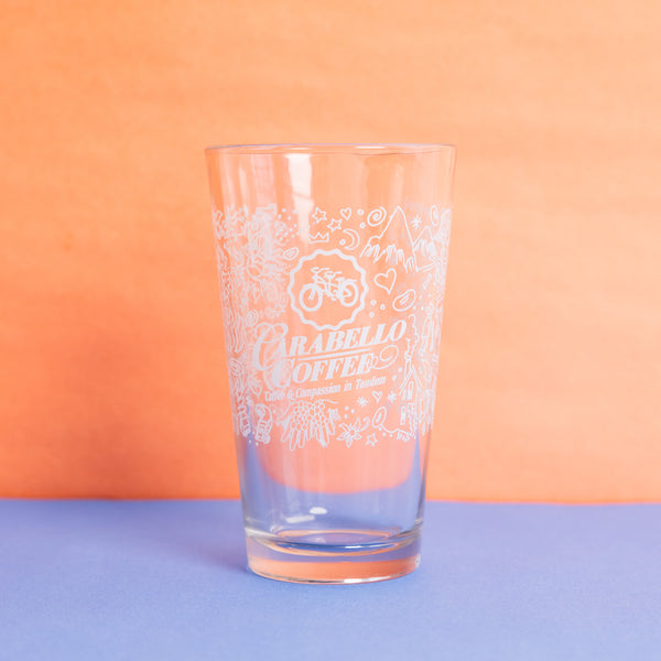 Clear pint glass featuring Carabello Coffee logo and doodles 