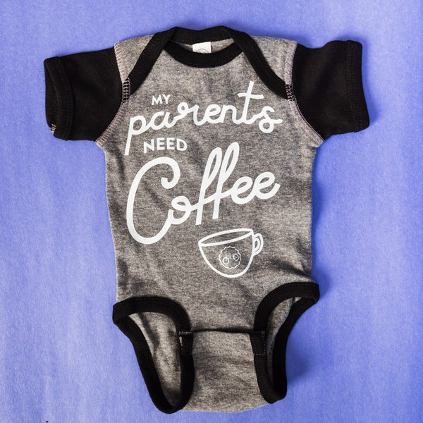 Gray baby onesie with black sleeves featuring the words "My  parents need coffee" 