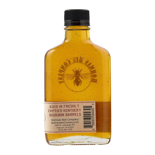 Bottle of honey with a black cap on a white background