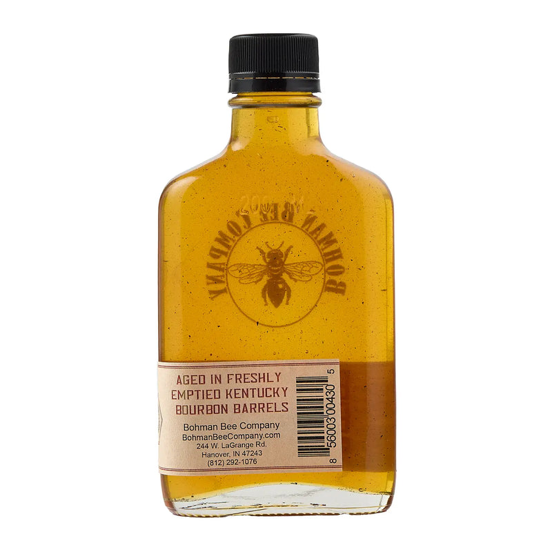 Bottle of honey with a black cap on a white background