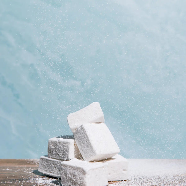 Stack of white marshmallows against a light blue snowy background
