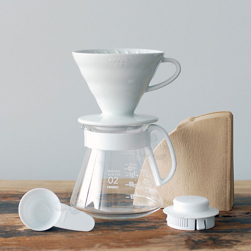 Ceramic v60 gift set with filters, a coffee scoop, a server and a brewer all in white.  
